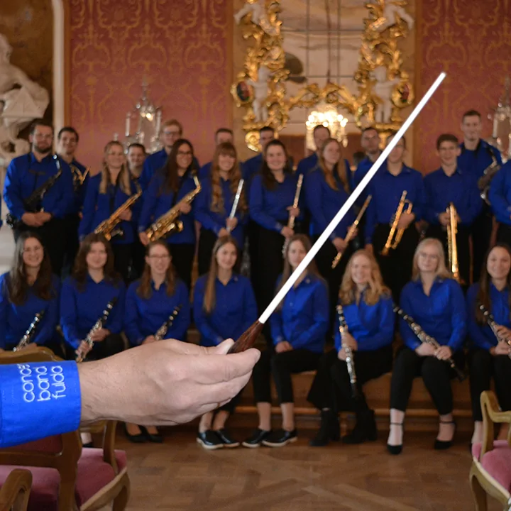 Die Concert Band Fulda mit einem Dirigierstab im Vordergrund